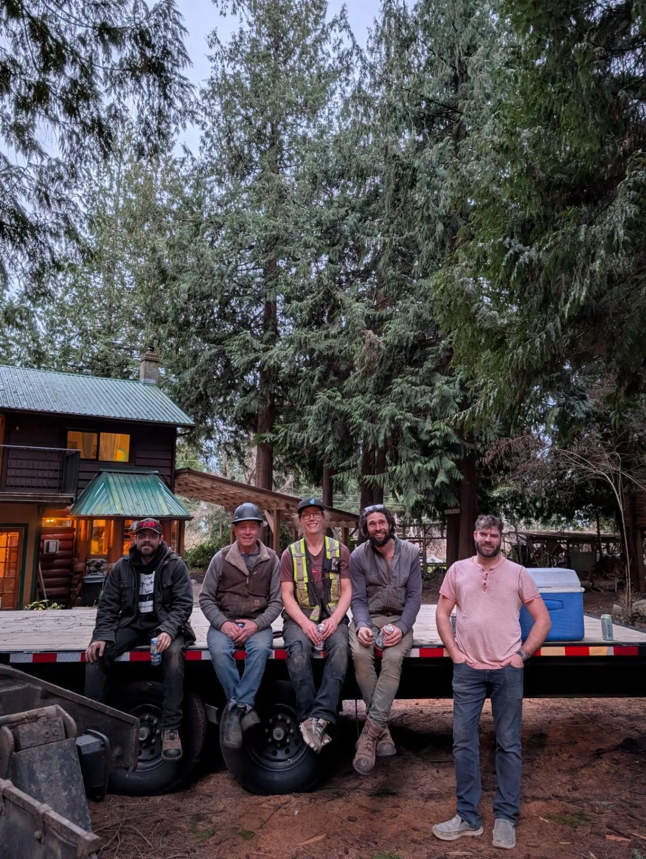 Fabutek team members gathered beside a trailer at a wooded project site.