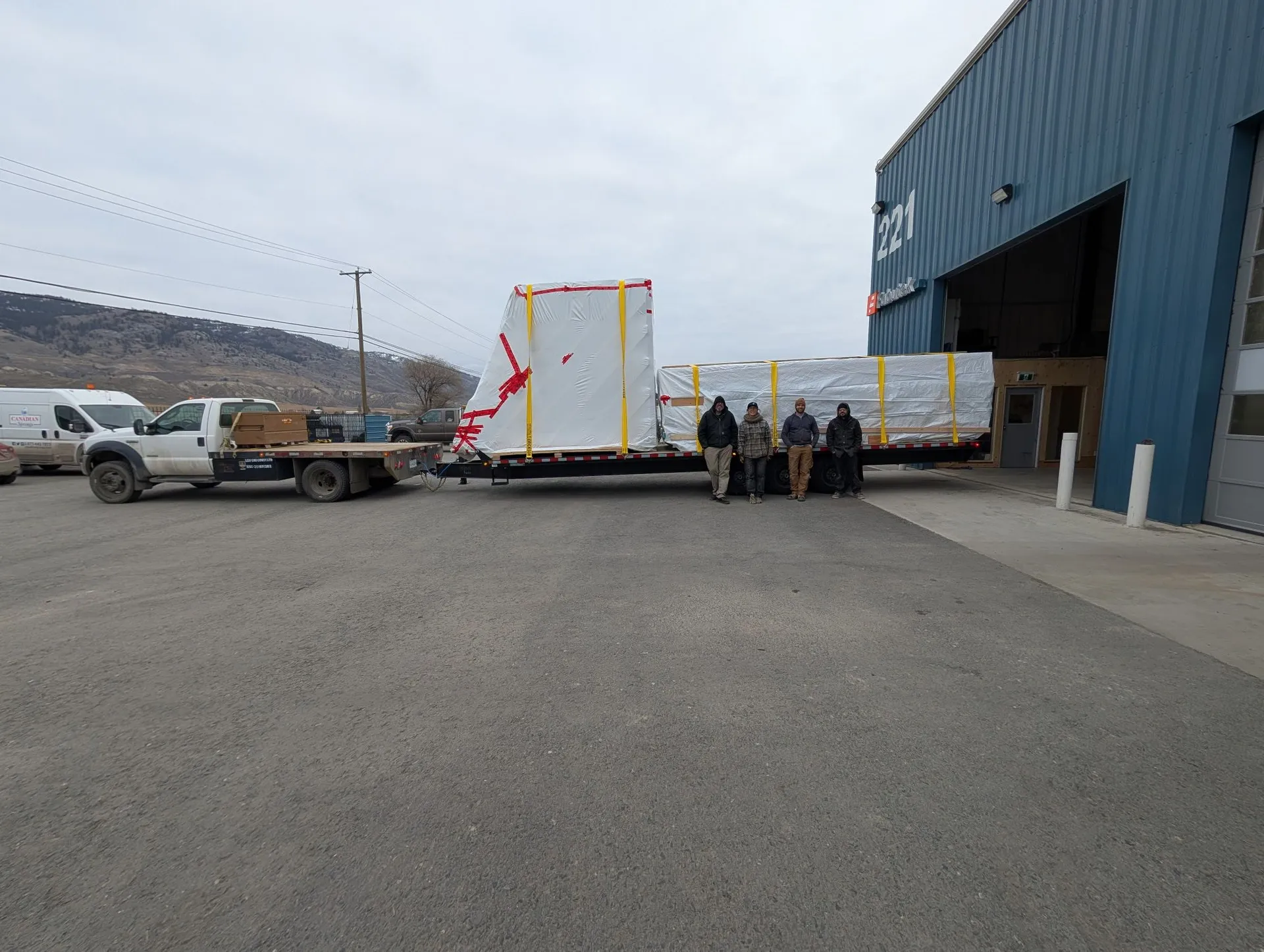 Wrapped building components secured on a trailer outside the Fabutek facility.